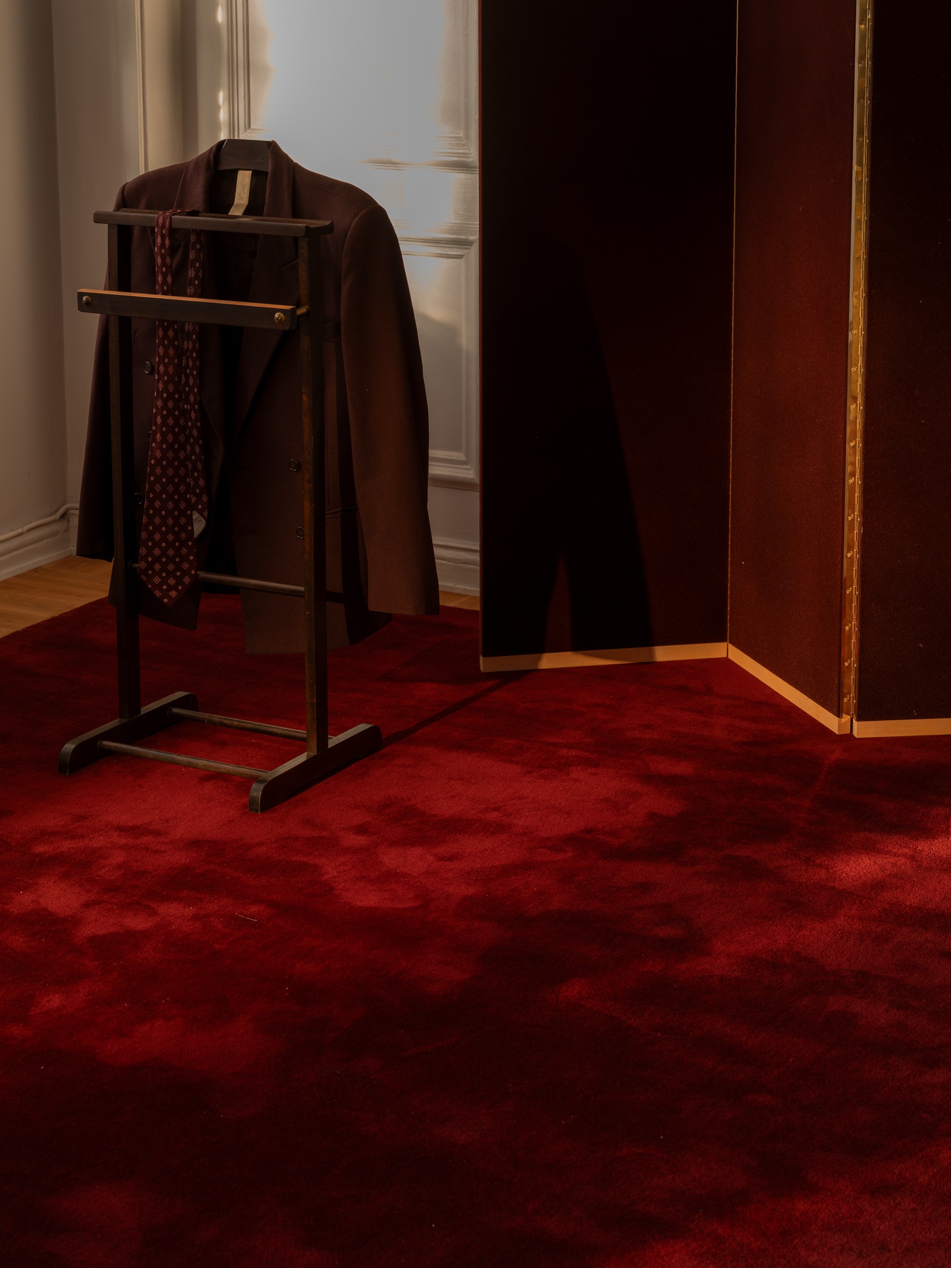 A Tie and suit jacket hanging on a rack