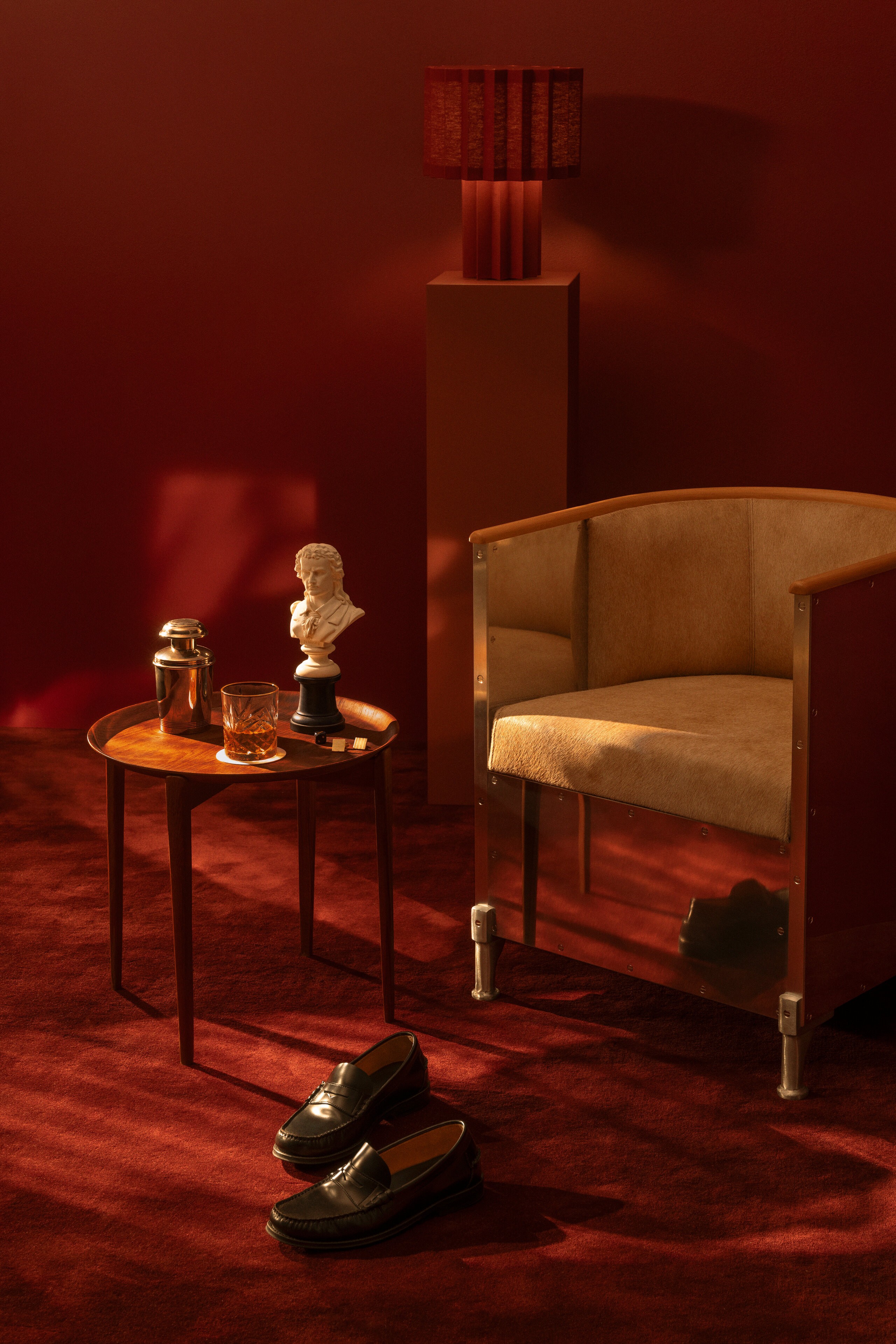 A chair, some shoes, a drink on a side table